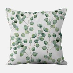 a white pillow with green leaves on it