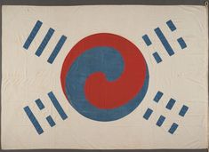 an old japanese flag with blue and red circles on it's side, hanging from a rope