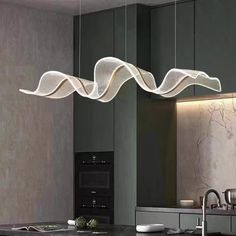 a modern light fixture hanging over a kitchen counter