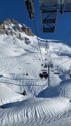 a ski lift going up the side of a snow covered mountain