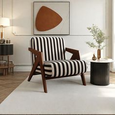 a striped chair sits in front of a painting on the wall next to a table