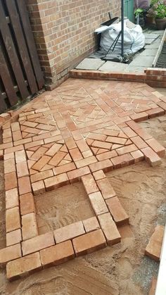 a brick patio being built in front of a building with bricks laid out on the ground