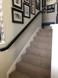 a staircase with pictures on the wall above it