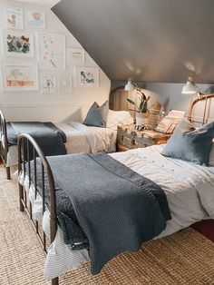 two beds in a room with pictures on the wall and carpeted floor, one is made up to look like an attic