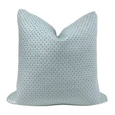 a blue and white pillow with dots on it's side, against a white background