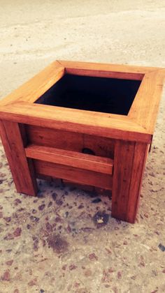 a small wooden table sitting on top of a sandy beach next to the ocean with no one around it