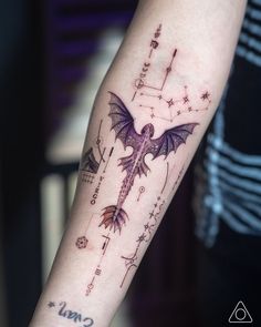 a tattoo on the arm of a person with a dragon and stars design on it