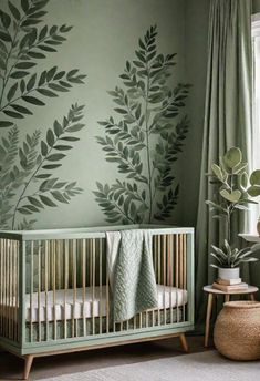 a baby crib in front of a green wall with leaves painted on it