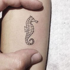 a small seahorse tattoo on the arm