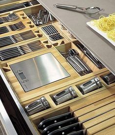 an organized drawer with utensils and knives