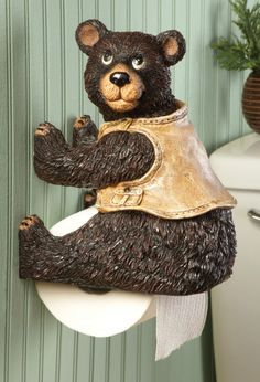 there is a bear that is sitting on a toilet paper holder with its paws in the air