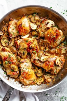 a pan filled with chicken and mushrooms covered in sauce