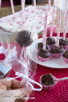 chocolate covered cupcakes are being held by someone's hand and wrapped in cellophane