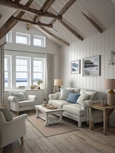 a living room filled with white furniture and wooden flooring next to a large window