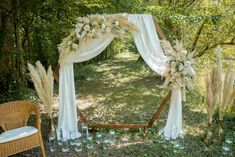 an outdoor wedding setup with white drapes and flowers