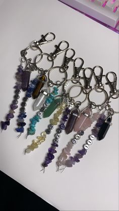 a bunch of key chains that are sitting on a table with some beads in them