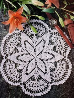 a white doily sitting on top of a table next to flowers