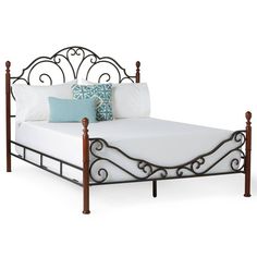 a metal bed frame with blue and white pillows