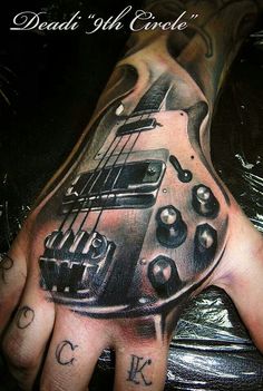 a man's hand with a guitar tattoo on it