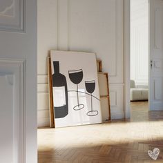 a wine glass is sitting on the floor next to a painting