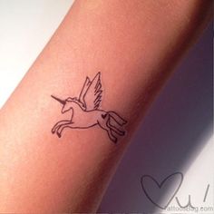 a small tattoo on the arm of a girl with a bird flying above her head