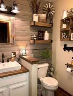 a white toilet sitting in a bathroom next to a wooden shelf filled with bottles and other items