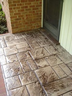 a close up of a tile floor near a brick building with a door and window