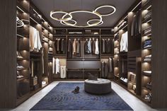 a large walk in closet with lots of clothes hanging on the walls and lights above it