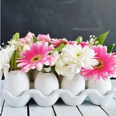 three white vases with pink and white flowers in them