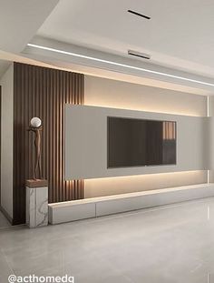 an empty living room with a flat screen tv on the wall and marble flooring