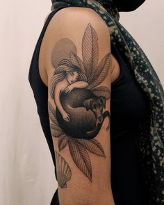 a woman with a tattoo on her arm holding a dog in the shape of a heart