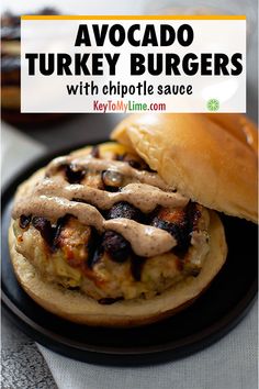 a close up of a burger on a plate with text overlay that reads, avocado turkey burgers with chipotle sauce