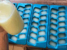 a glass of milk sitting on top of an ice tray next to a container of eggs