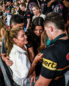 a group of people standing next to each other in front of a crowd at a sporting event