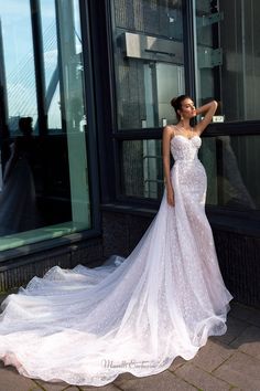 a woman in a wedding dress leaning against a window