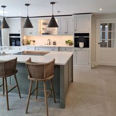 a kitchen with two bar stools and an island in front of the counter top