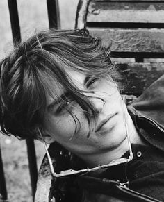 black and white photograph of a young man with his hair blowing in the wind, taken from behind