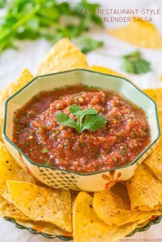 a bowl filled with salsa surrounded by tortilla chips