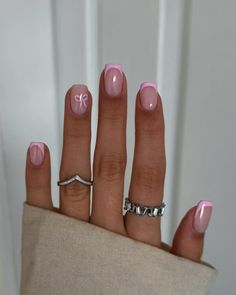 Elevate your manicure with Baby Pink French Tip Nails adorned by charming pink bow accents on the ring finger. This delightful design merges classic elegance with a playful twist, featuring soft baby pink French tips that exude sophistication. The addition of dainty pink bow accents adds a touch of whimsy and femininity, creating a look that’s both refined and adorable. Perfect for those who appreciate a blend of timeless beauty and modern flair, these nails are sure to make a statement with their irresistible charm. Pink French Tips Natural Nails, Pink French Tip Nails With Pink Base, Short French Tip Acrylic Nails Christmas, Xmas Nails Short Simple, Short Pink Dip Nails, Pink French Tip With Bow, Pink French Short Nails, Pink French Tips With Design, French Nails With Accent Nail