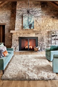 a living room filled with furniture and a fire place next to a stone wall fireplace