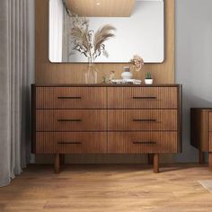 a wooden dresser sitting next to a mirror on top of a wall in a room