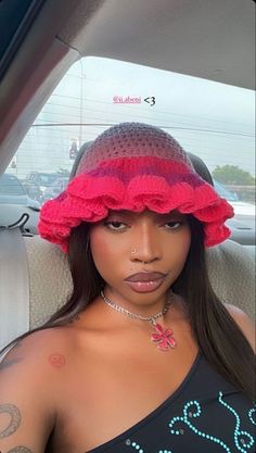 a woman in a car wearing a pink hat