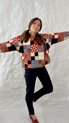 a woman standing in front of a white backdrop with her arms spread out to the side