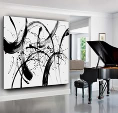 a black and white painting on the wall next to a piano in a living room