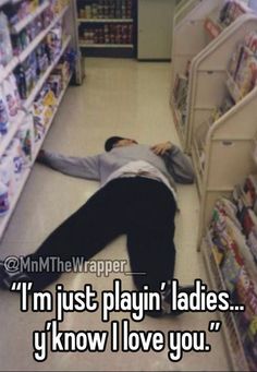 a man laying on the ground in front of a store aisle with his head down