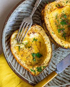 two stuffed potatoes on a plate with a fork