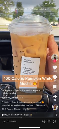 someone holding up a cup of iced coffee in their car with the caption, 100 calorie pumpkin white mocha