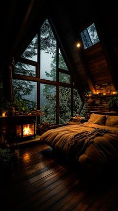 a bedroom with a large window and wooden flooring, lit by lights from the windows