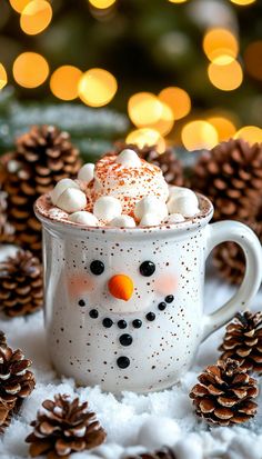 a cup filled with hot chocolate and marshmallows sitting on top of snow