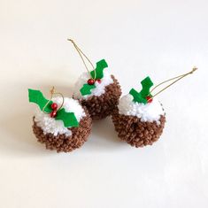 two small crocheted christmas puddings with holly decorations